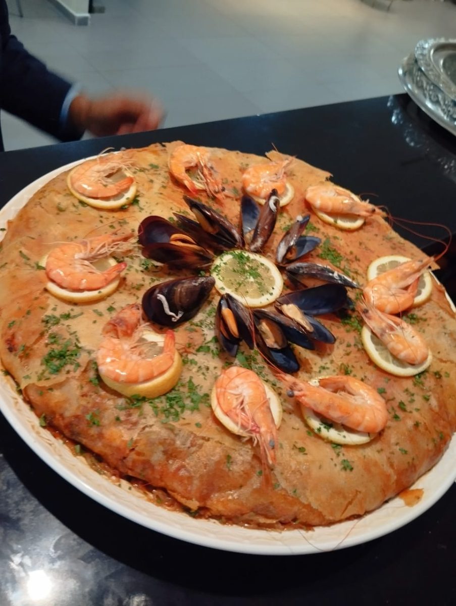 Pastilla aux fruits de mer sur une assiette blanche
