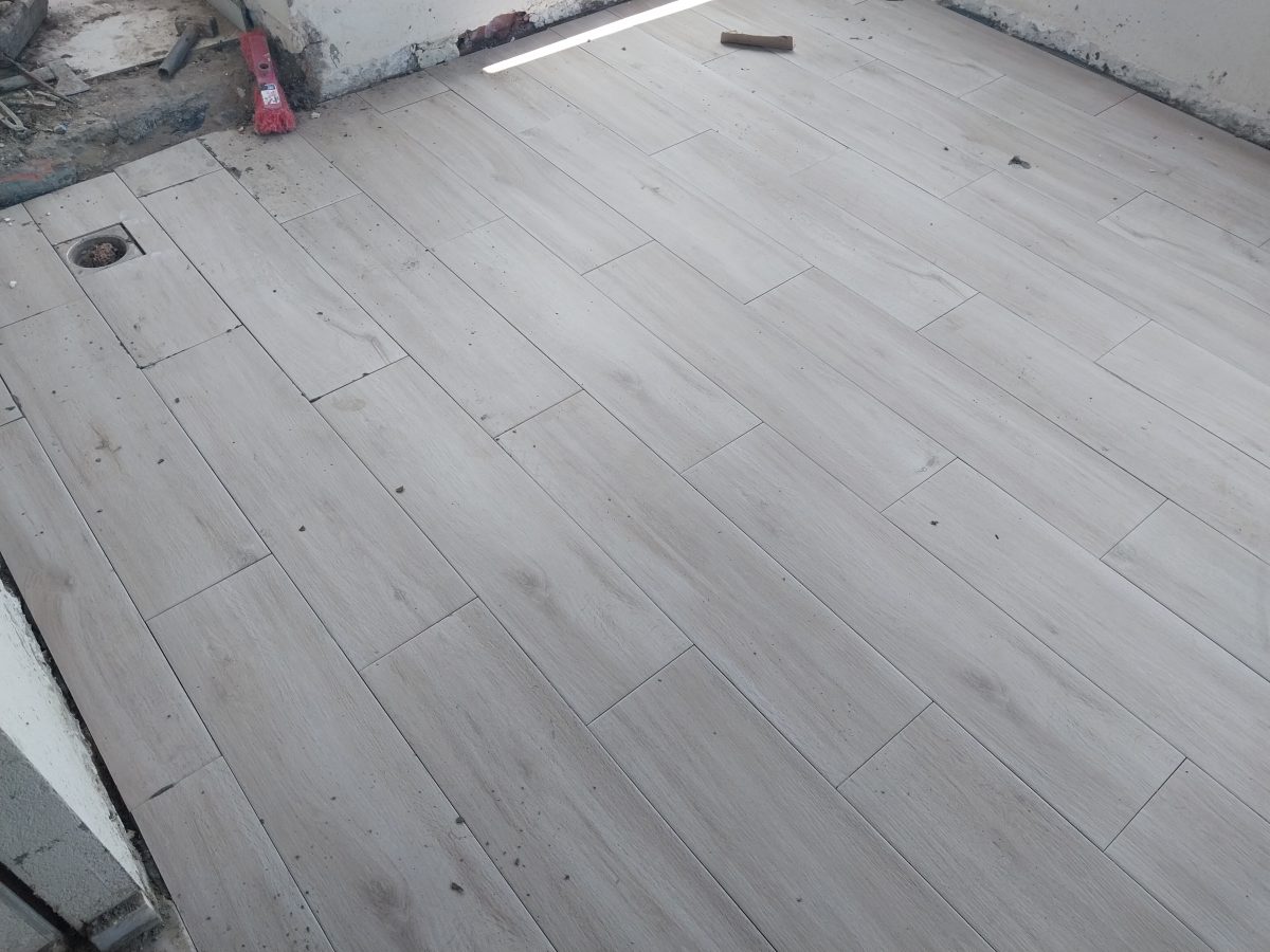 Sol carrelé effet parquet bois avec siphon, en cours de pose