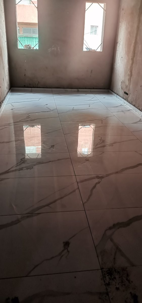 Sol carrelé effet marbre poli rose veiné dans une pièce