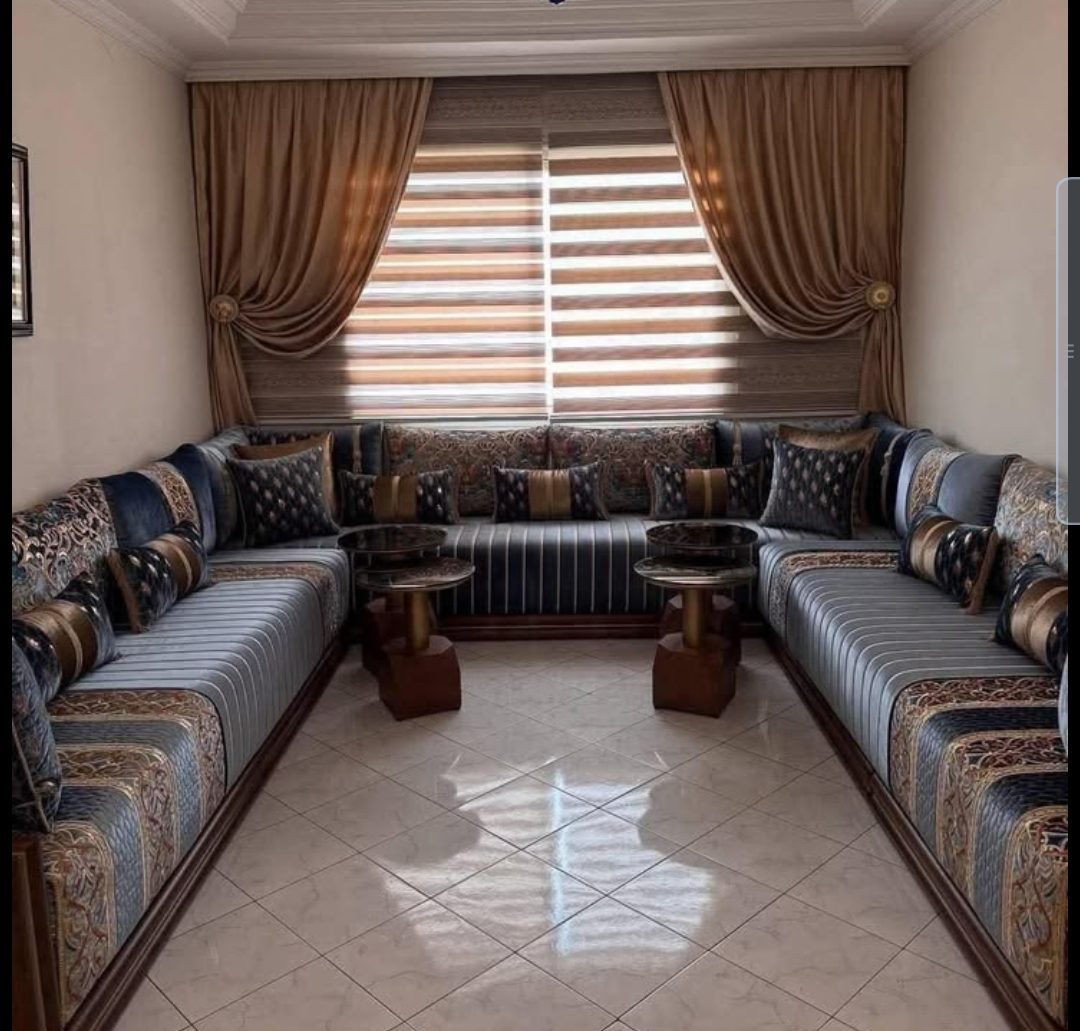 Salon marocain raye bleu-gris à coussins brocart et rideaux dorés