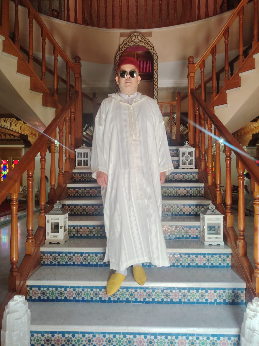Homme en djellaba blanche et tarbouche sur un escalier en zellige