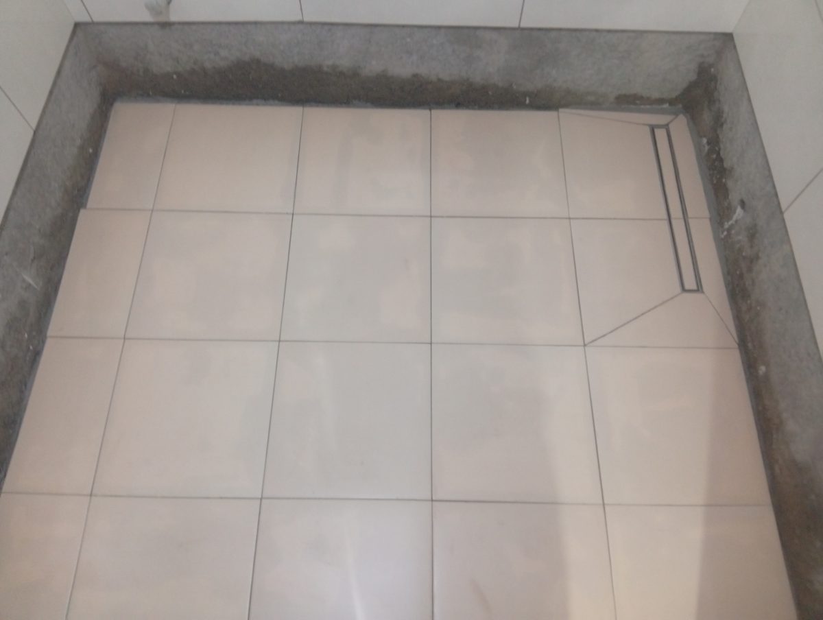 Pose de carrelage de sol grand format avec caniveau de douche