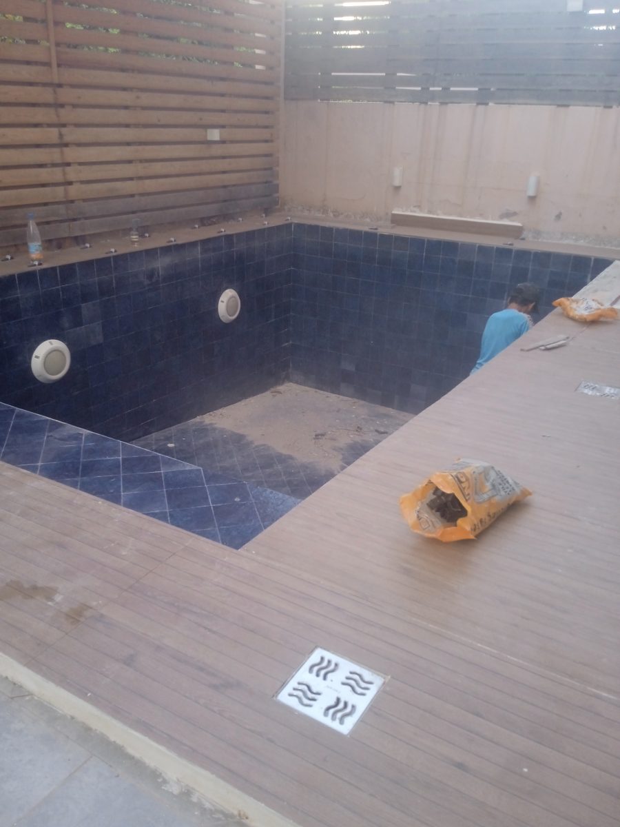 Piscine habillée de zellige bleu avec margelle et plage en bois composite
