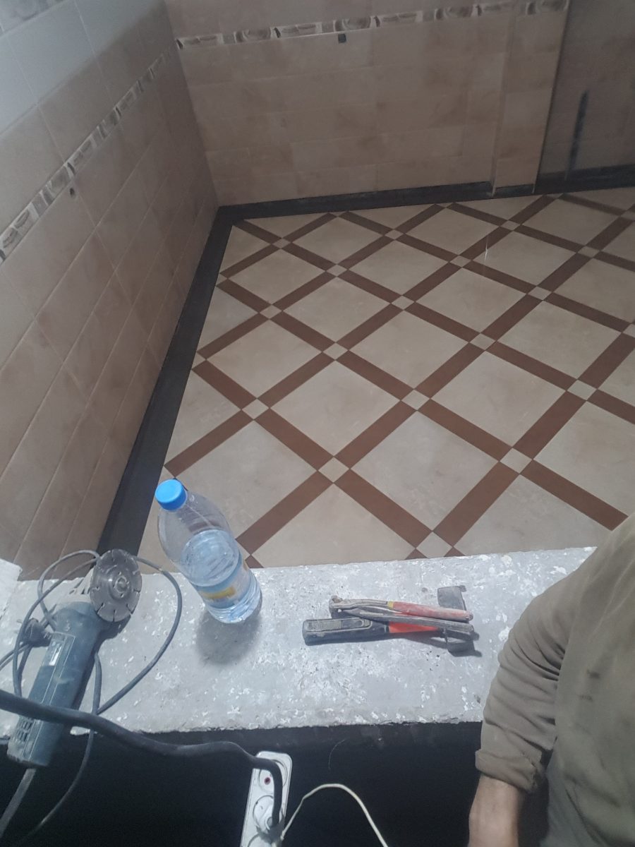 Pose de carrelage de sol à motif damier bicolore crème et marron