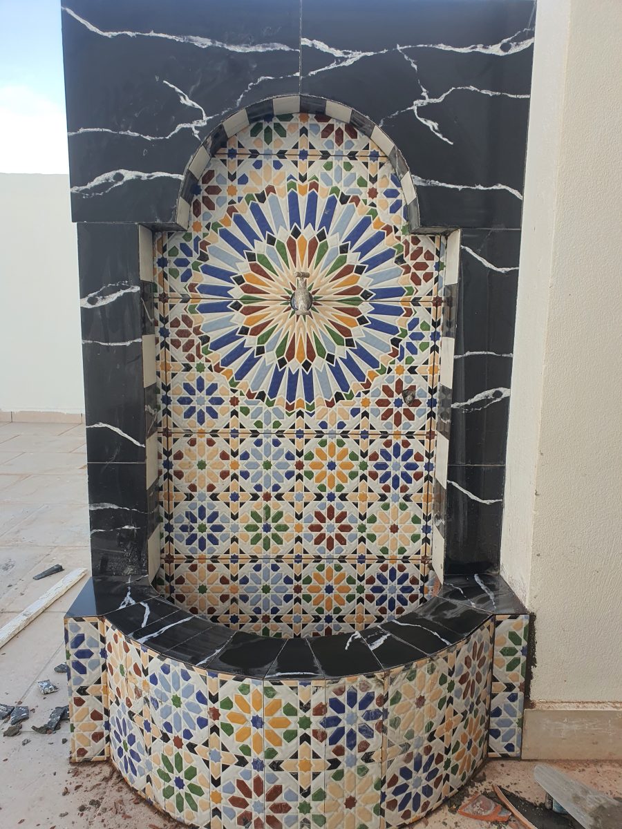 Fontaine murale en zellige à rosace polychrome encadrée de marbre noir