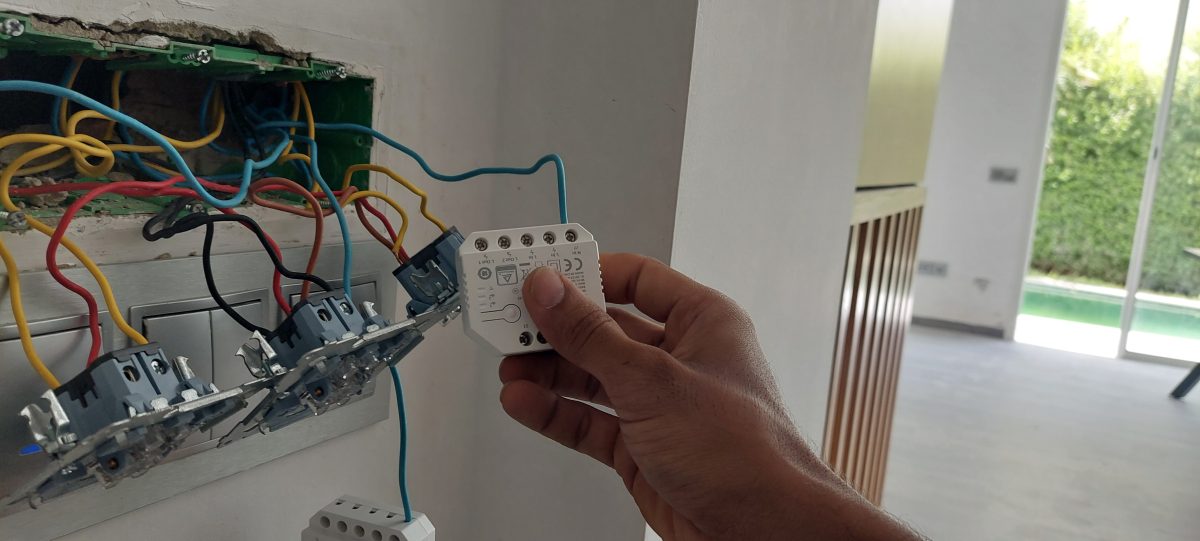 Pose d'un micromodule domotique derrière des interrupteurs muraux