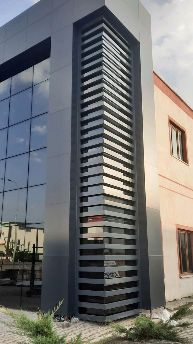 Habillage d'angle en aluminium à lames ajourées sur façade vitrée