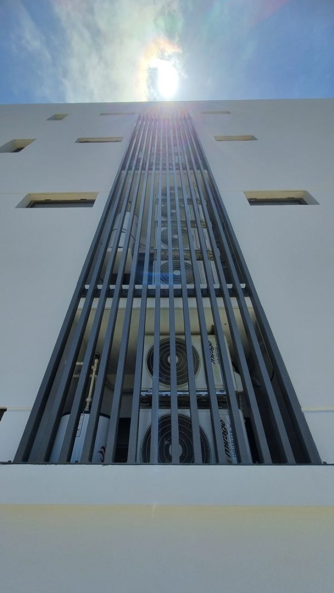 Cache-groupes de climatisation en aluminium à lames verticales sur façade