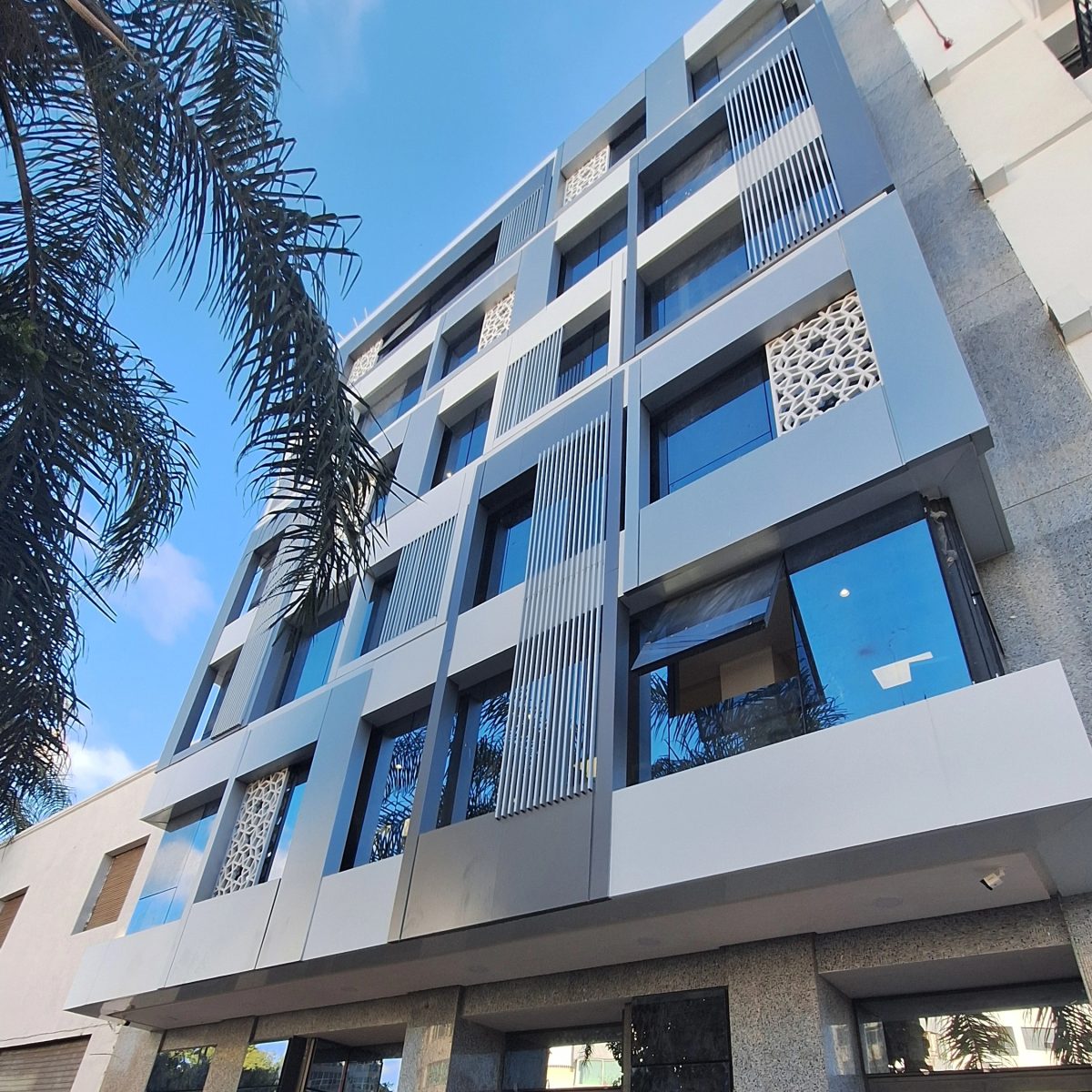 Façade d'immeuble habillée d'aluminium à lames et panneaux moucharabieh