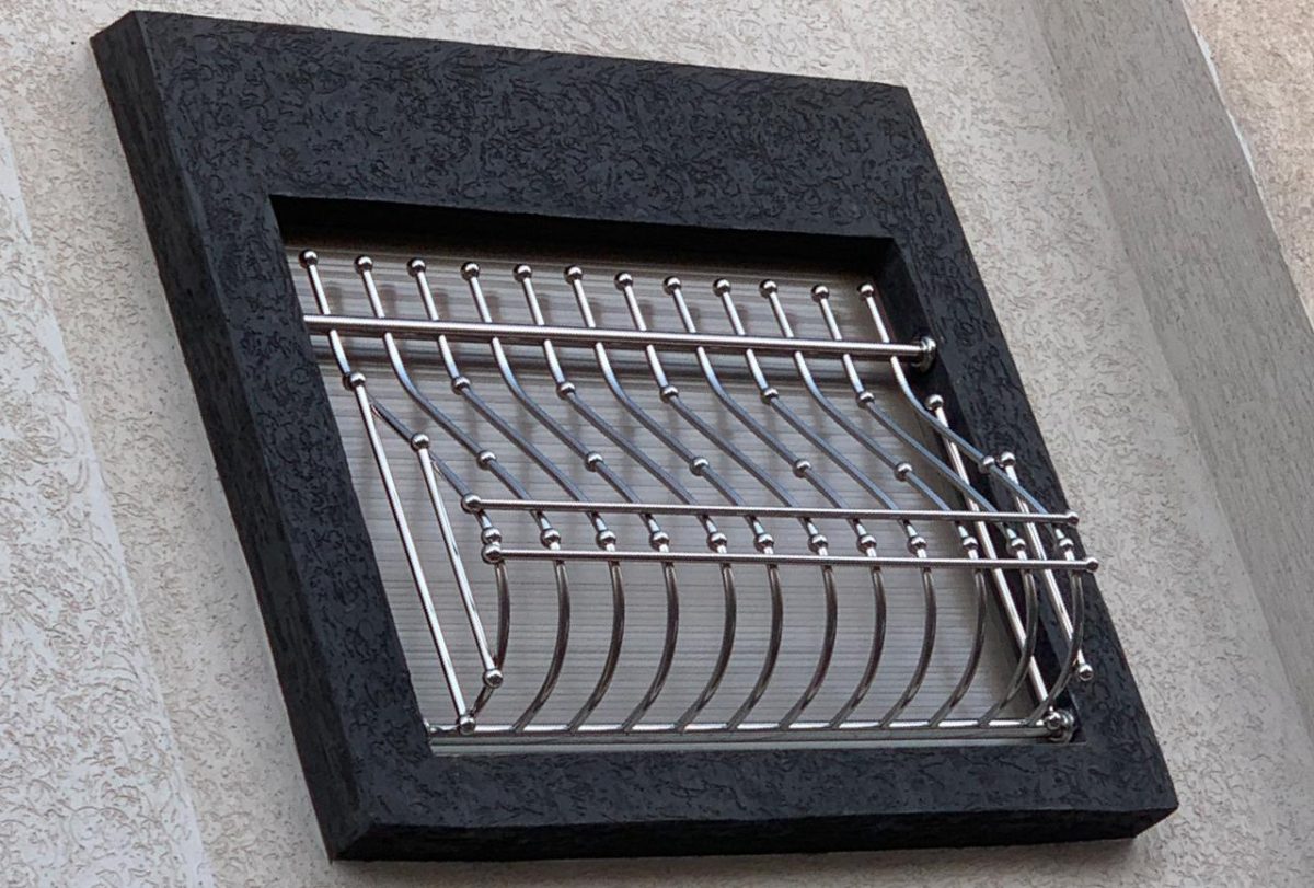 Grille de défense de fenêtre en inox à barreaux cintrés, sur encadrement foncé