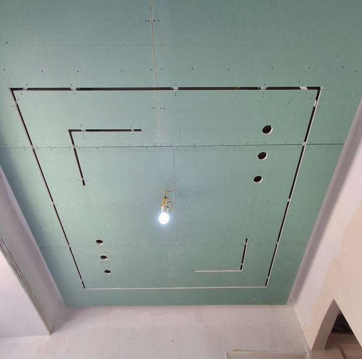 Structure de faux plafond en plaques de plâtre (BA13) en cours de pose