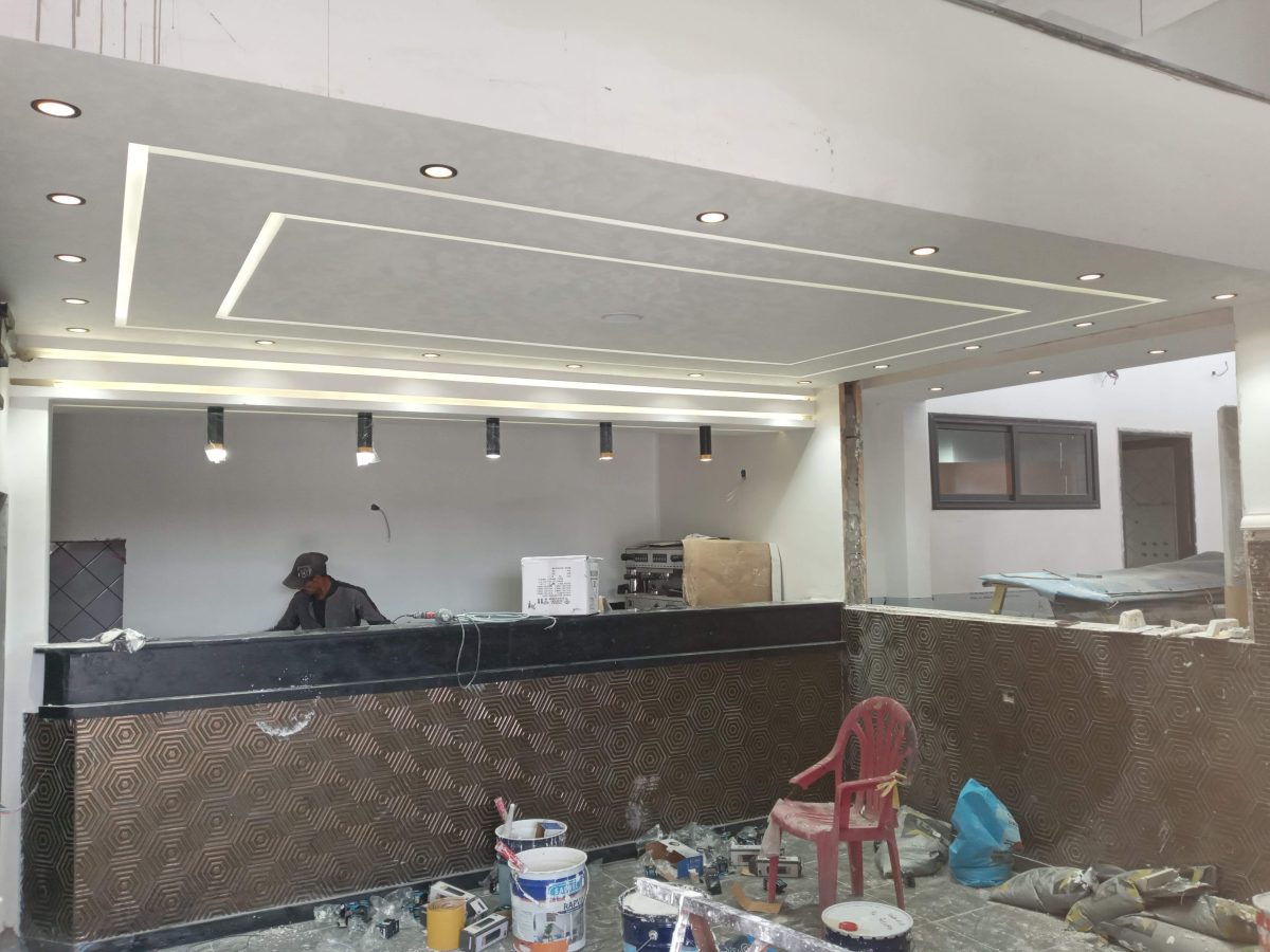 Café en aménagement avec faux plafond LED et comptoir habillé