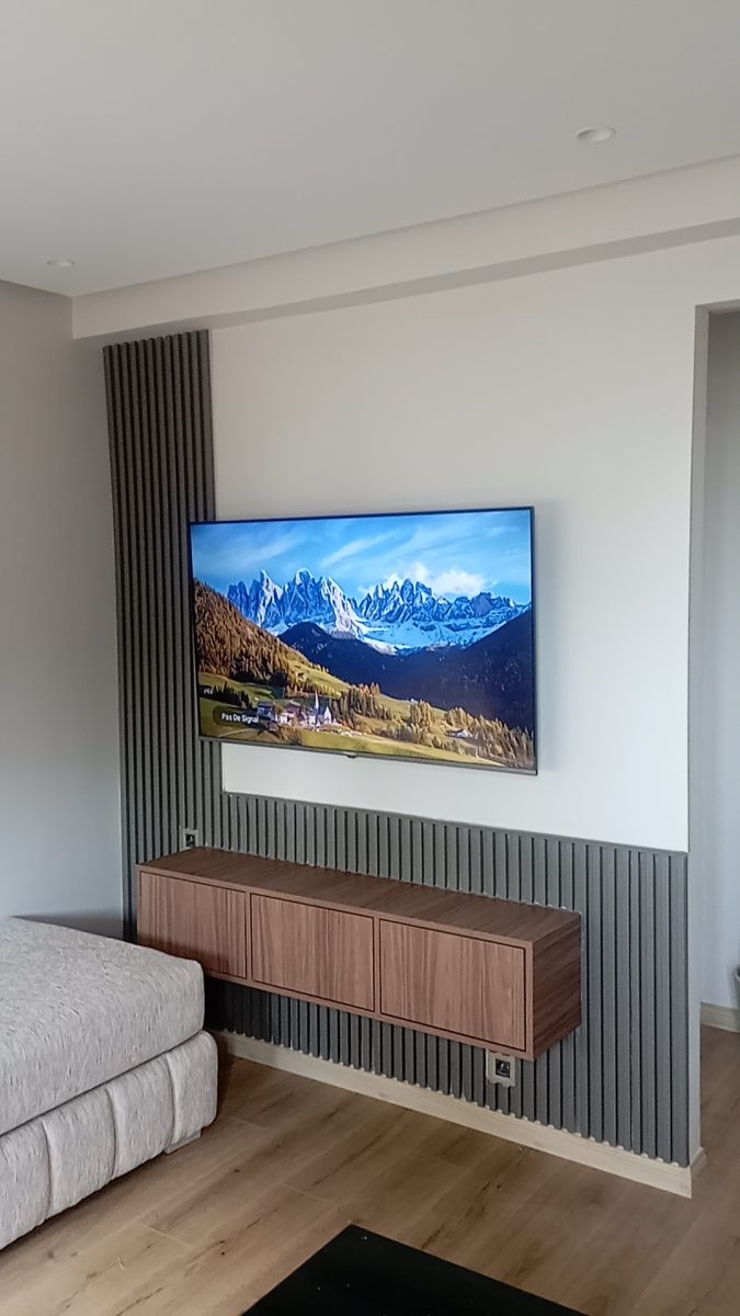 Mur TV habillé de tasseaux gris avec meuble bois suspendu
