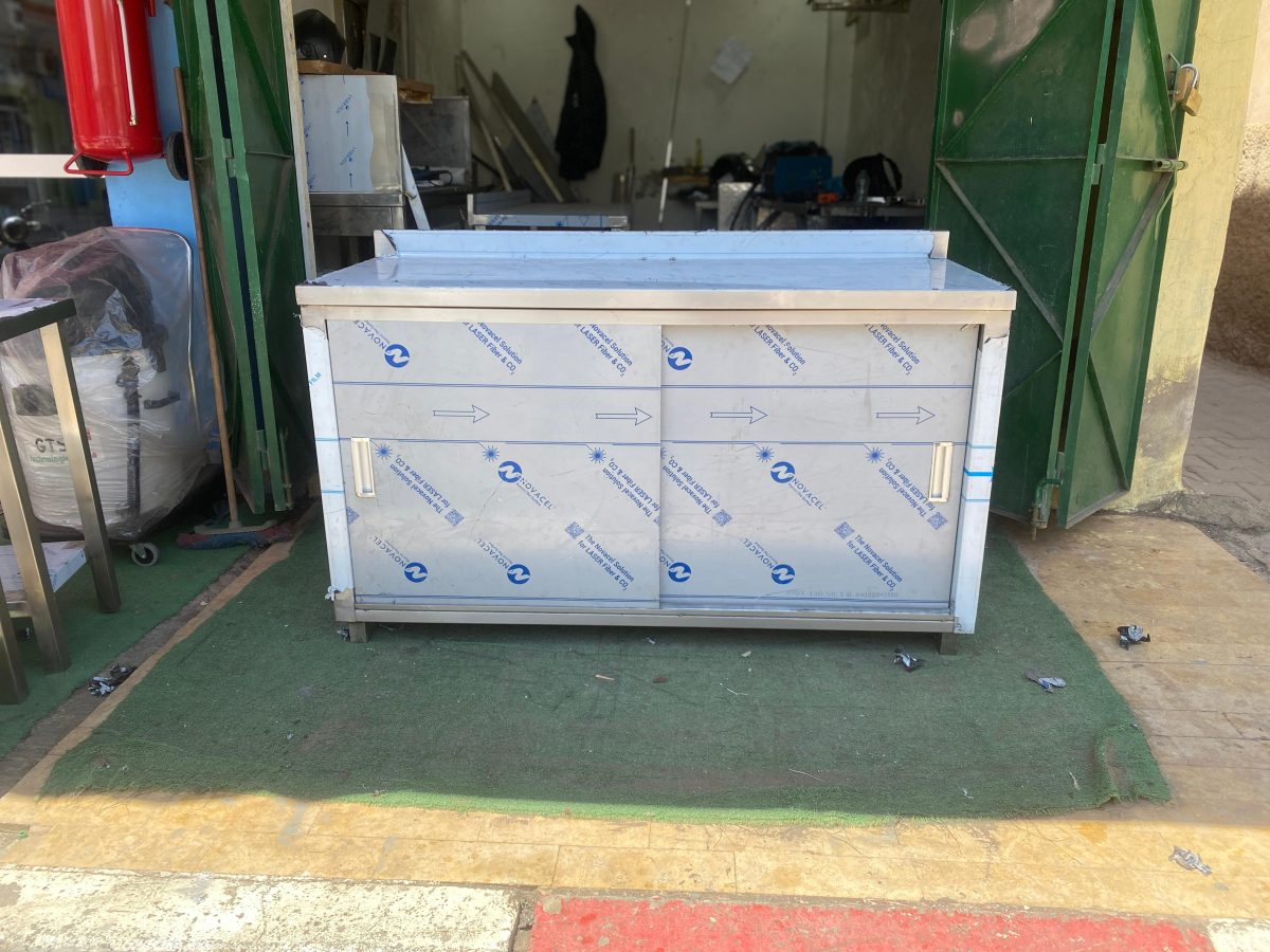 Meuble bas en inox à portes coulissantes en atelier