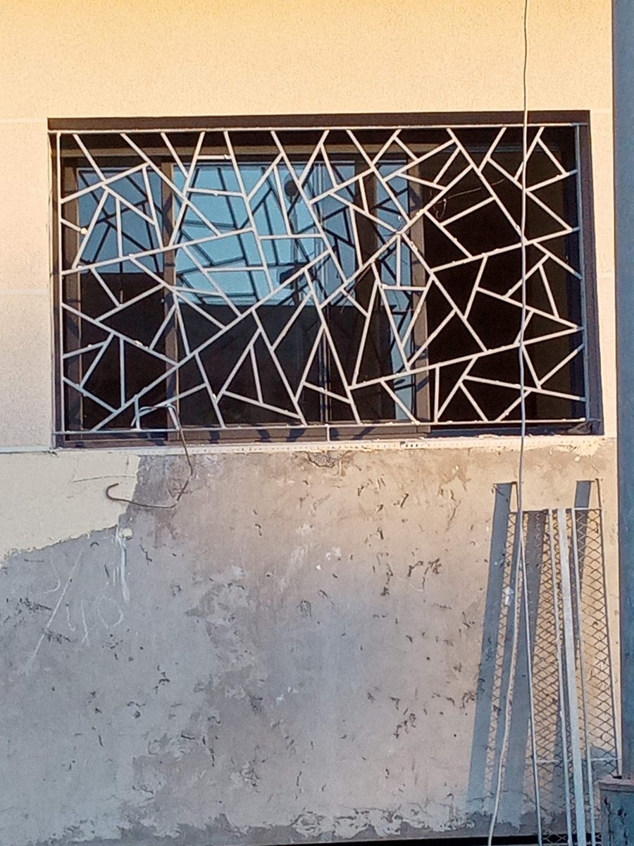 Grille de fenêtre en fer forgé gris à motif géométrique eclate