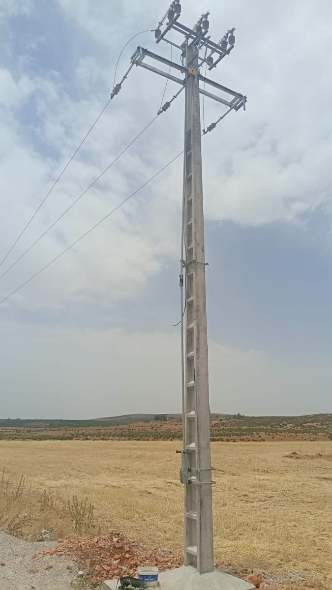 Poteau électrique moyenne tension avec isolateurs en zone rurale