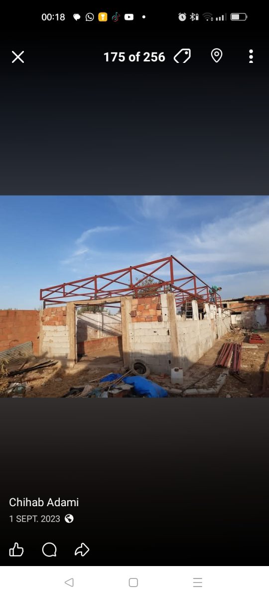 Charpente métallique en treillis rouge sur une construction en briques