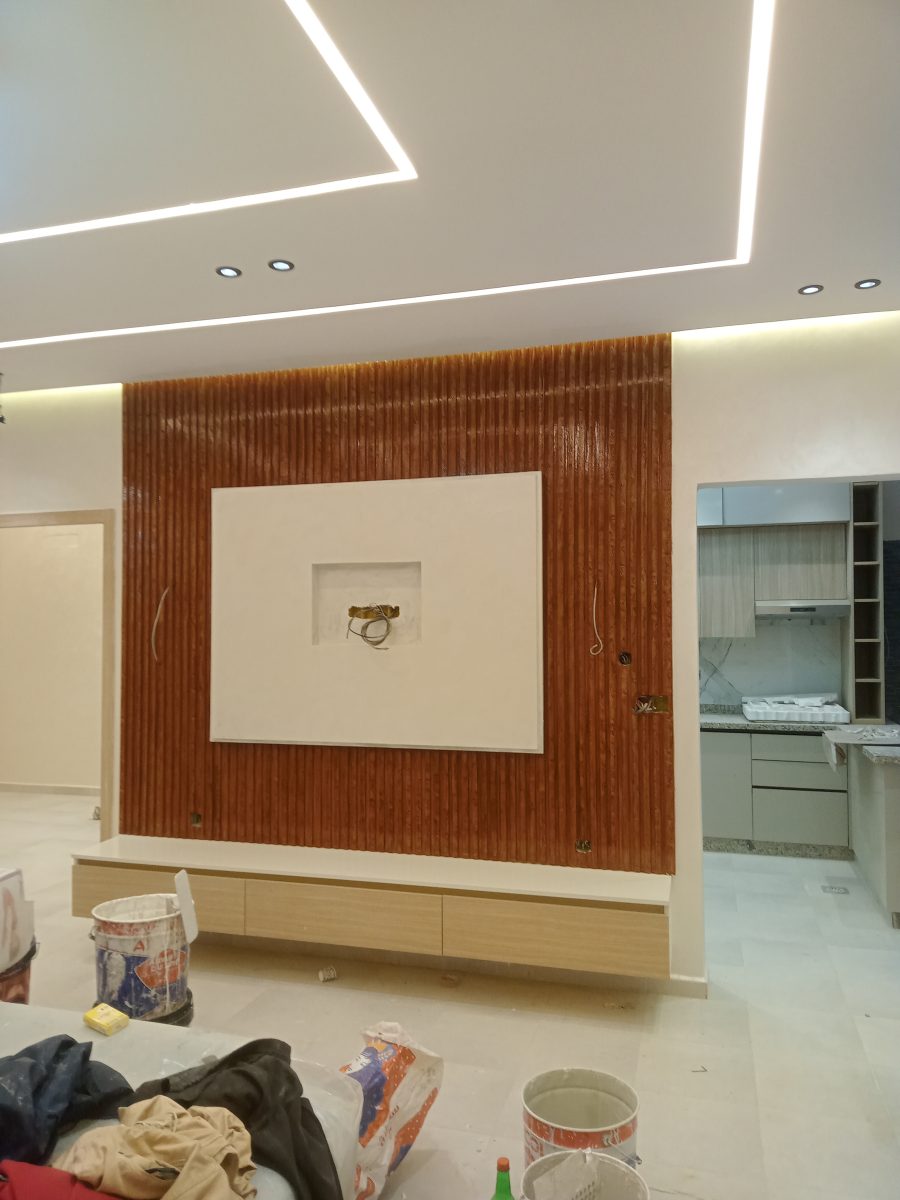 Mur TV habillé de tasseaux de bois terracotta et faux plafond LED