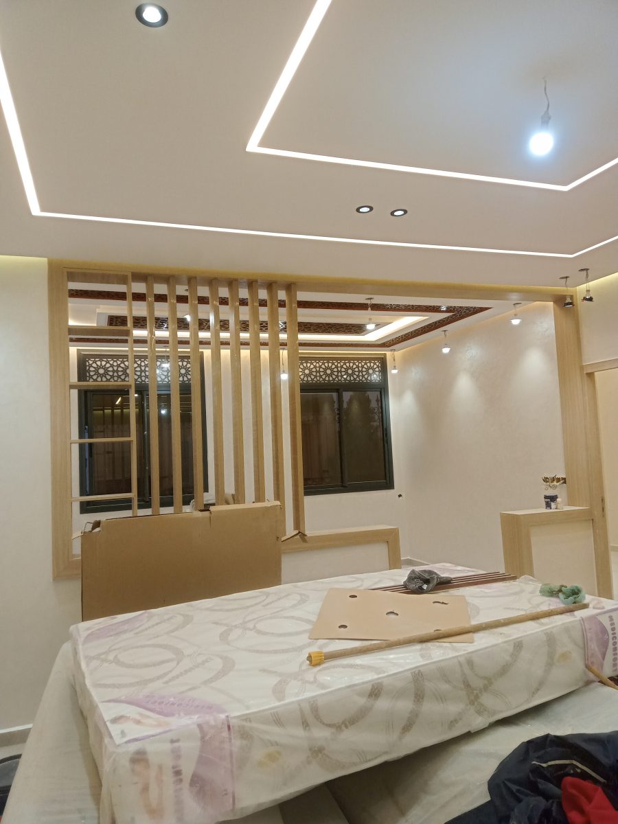 Séparation en claustra de bois et faux plafond LED dans une pièce peinte