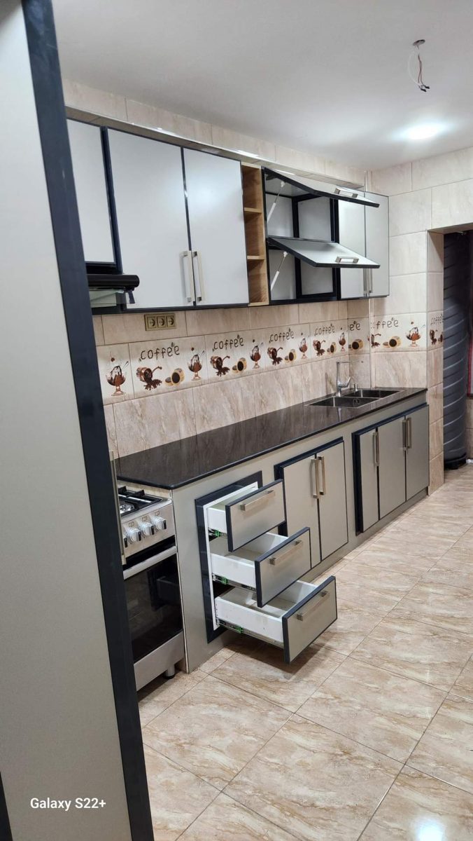 Cuisine en aluminium gris et blanc avec plan en granit et frise de tasses