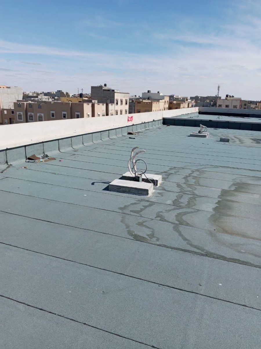 Toiture-terrasse recouverte d'une membrane d'étanchéité grise, vue urbaine