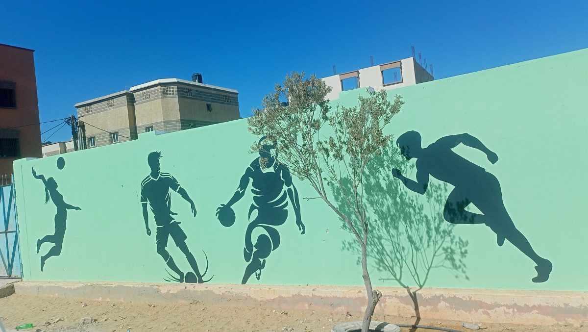 Fresque murale de silhouettes de sportifs sur un mur vert