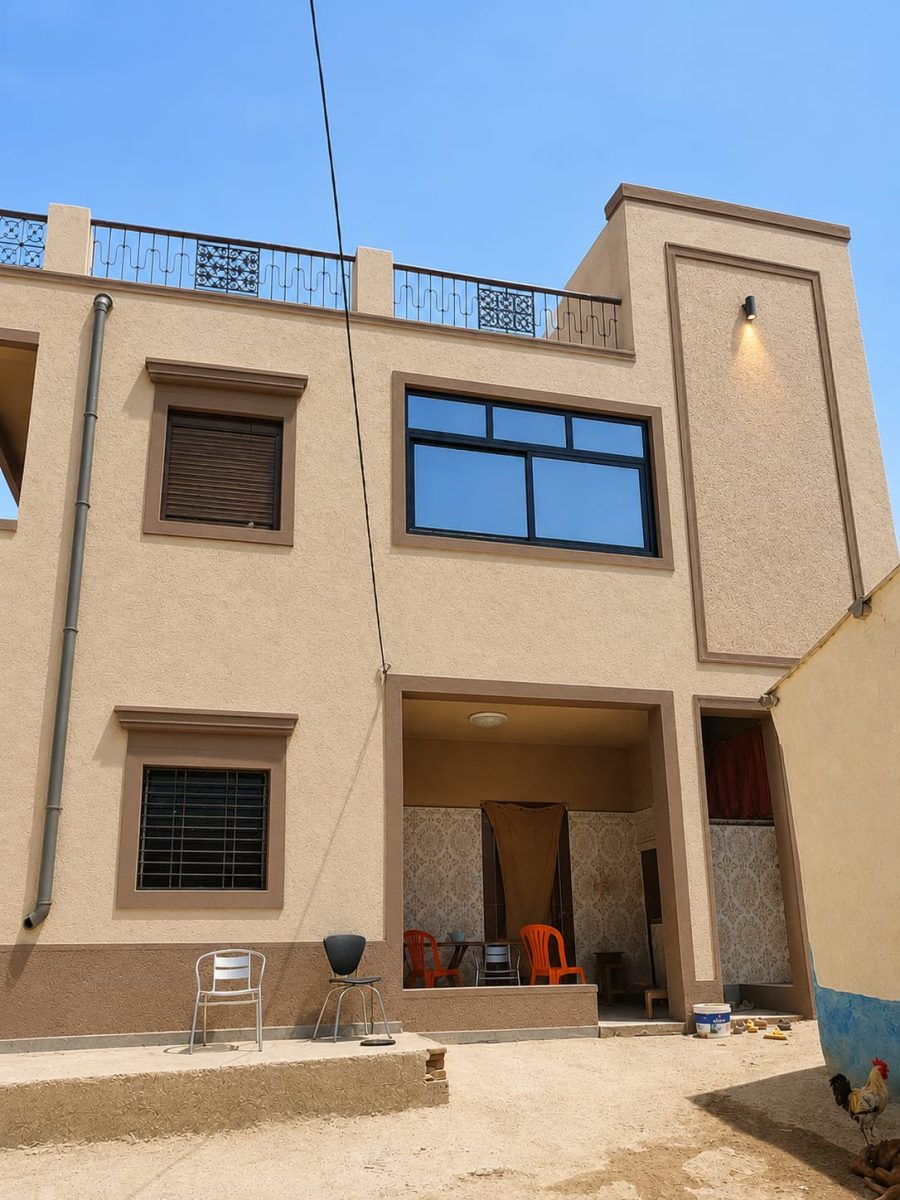 Façade de maison en enduit décoratif beige avec encadrements