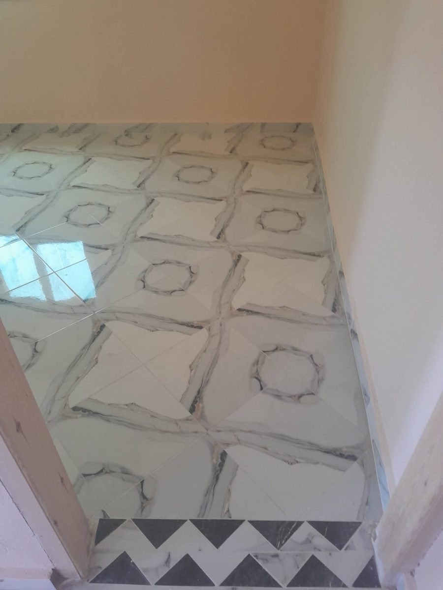 Sol carrelé effet marbre à motif d'octogones et bordure zigzag