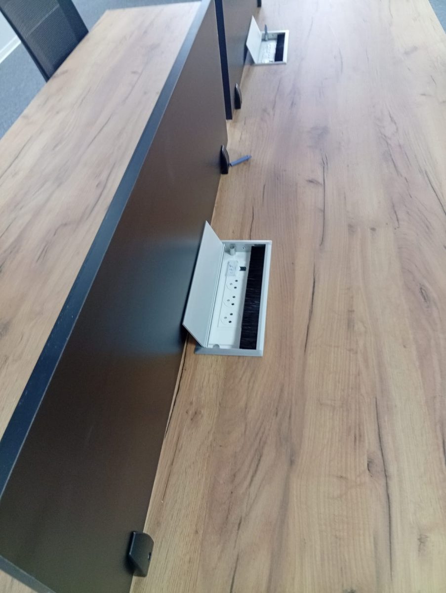 Boîtier de connectique escamotable avec prises intégré dans un plan de bureau