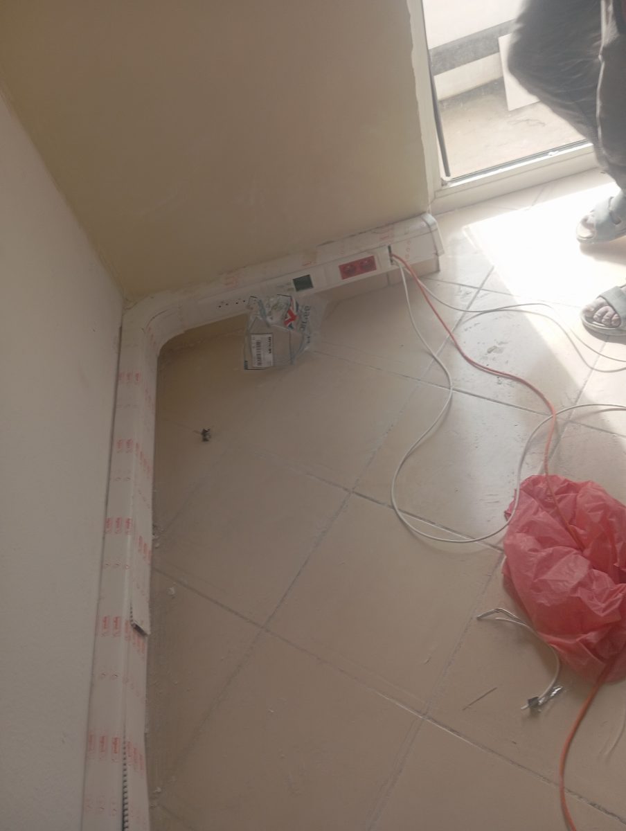 Pose de goulottes et prises électriques en angle de pièce