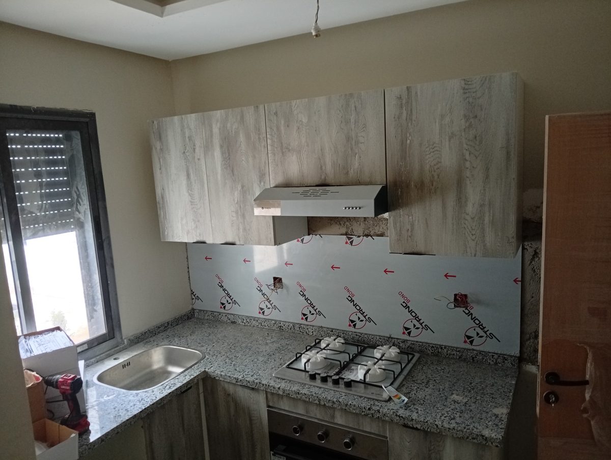 Cuisine effet bois gris avec plan en granit et plaque de cuisson