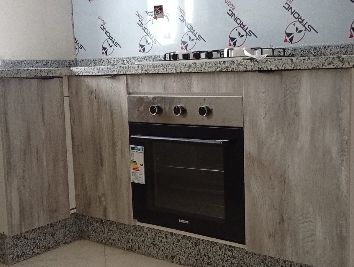 Meubles bas de cuisine effet bois gris avec four encastré et plan en granit