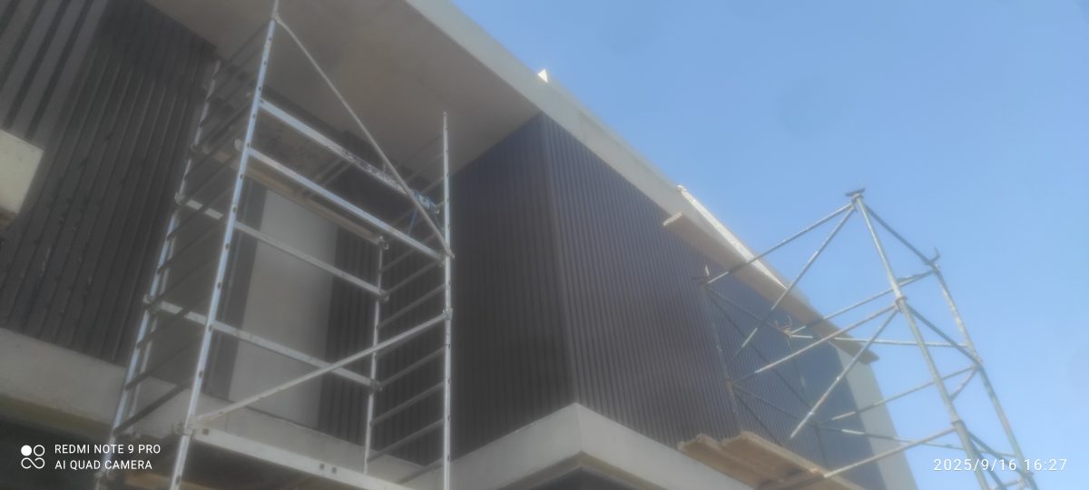 Bardage métallique de façade en cours de pose sous échafaudage