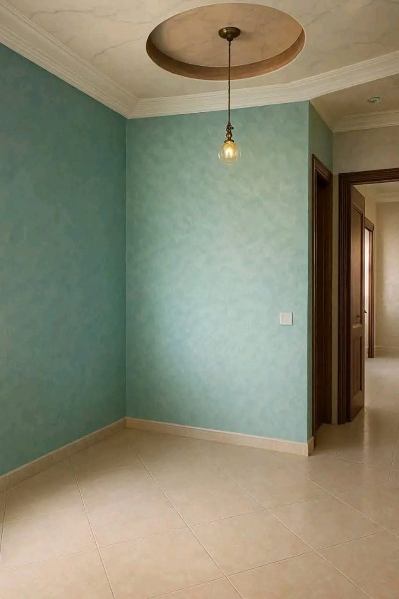 Pièce aux murs en peinture décorative vert d'eau et faux plafond à rosace