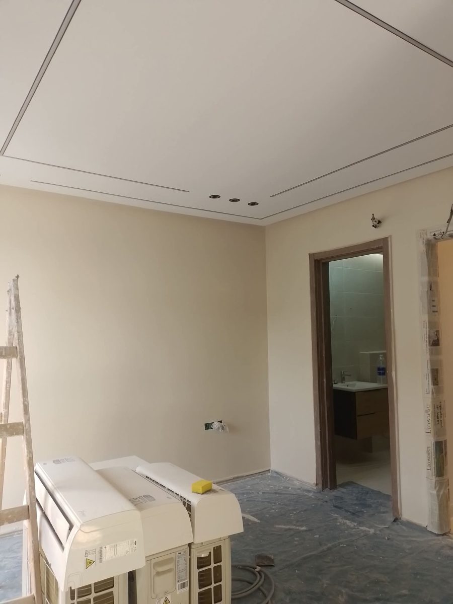 Pièce peinte en beige avec faux plafond à spots, en fin de chantier