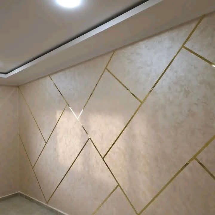 Mur en peinture décorative nacrée avec baguettes dorées géométriques