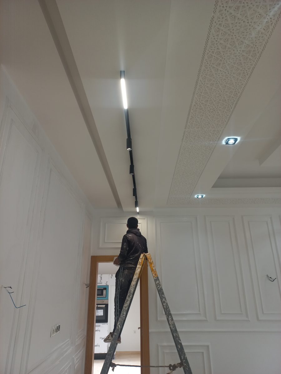 Pose d'un éclairage sur rail magnetique noir dans un couloir