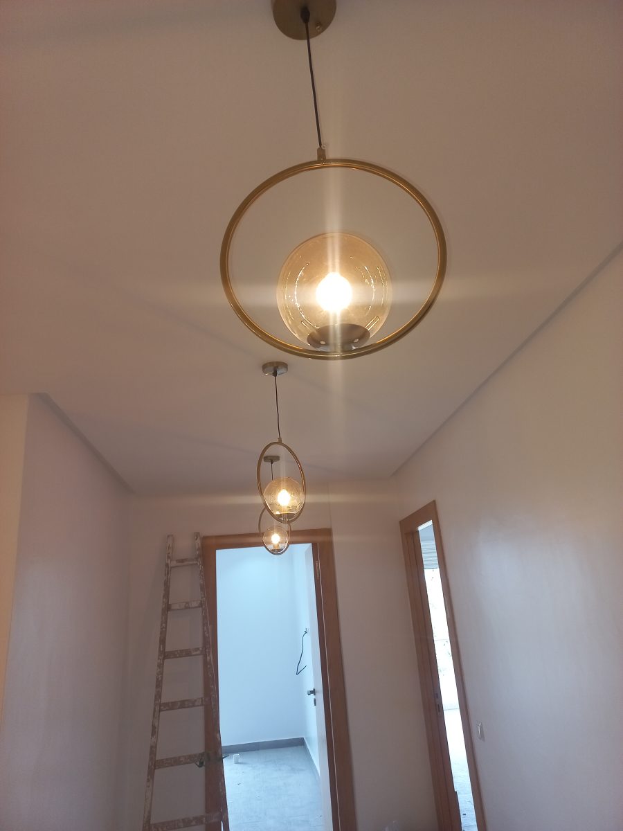 Suspension à anneaux dorés et globes ambres, en pose