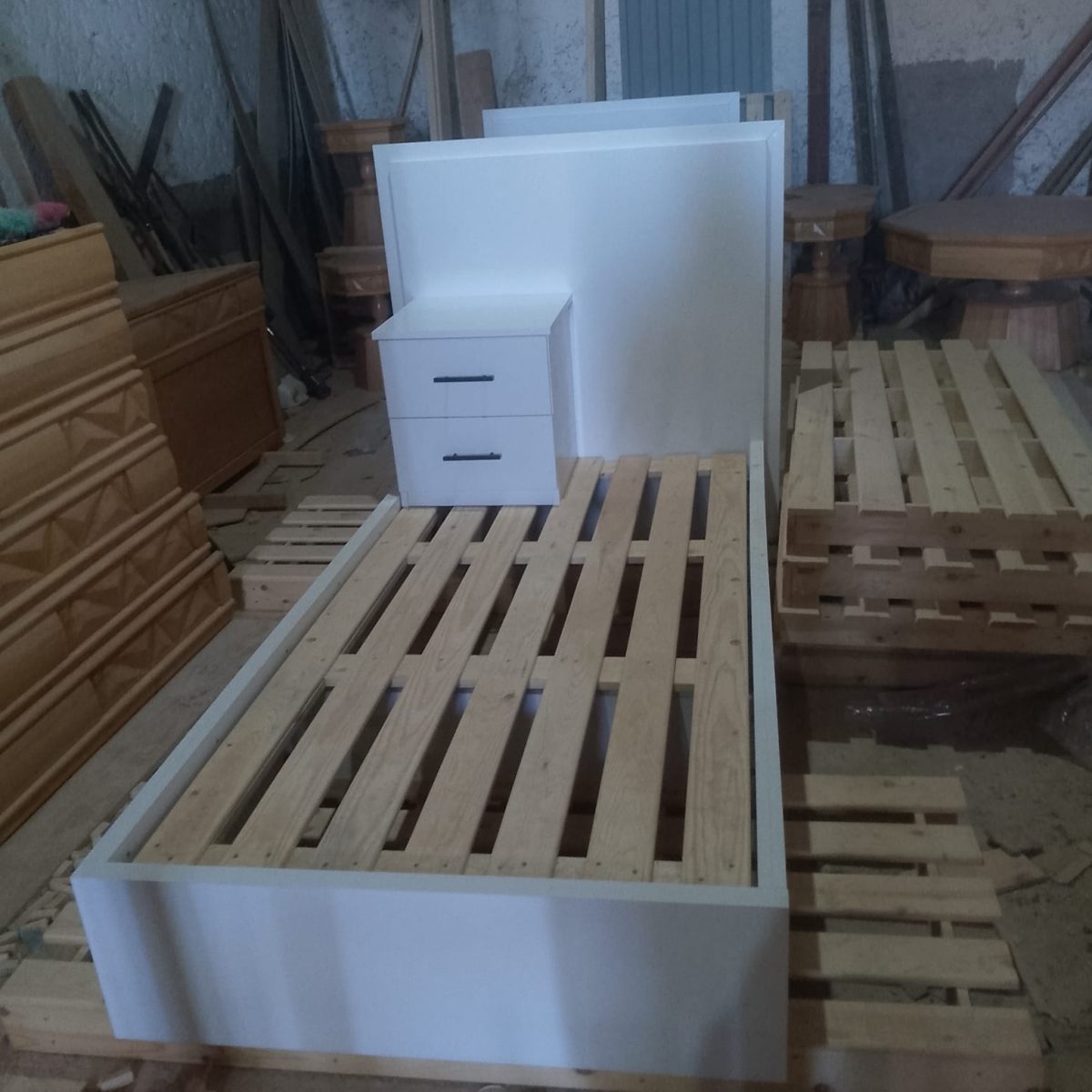 Lit et chevet blancs en cours de fabrication en atelier