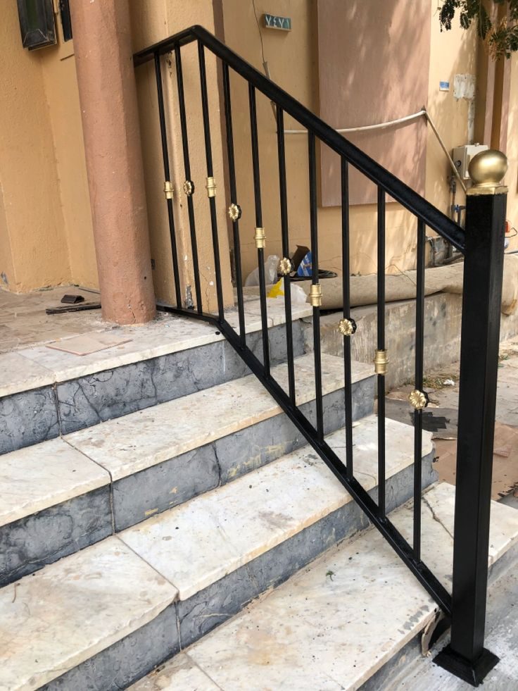 Rampe d'escalier en fer forgé noir avec fleurons dorés