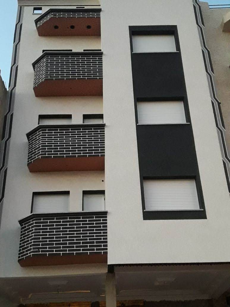 Façade d'immeuble avec balcons en parement brique et enduit clair