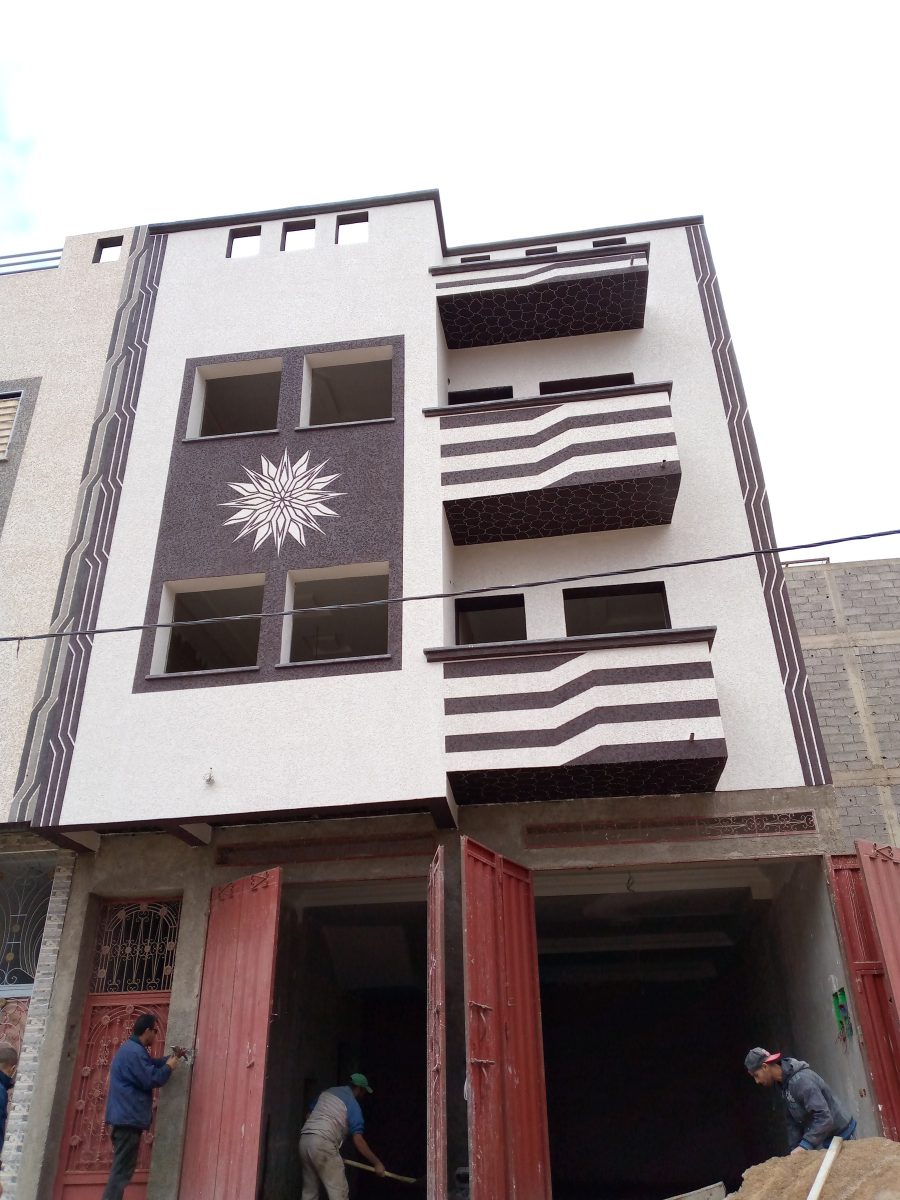 Façade de maison à décor peint (rosace et balcons rayés)