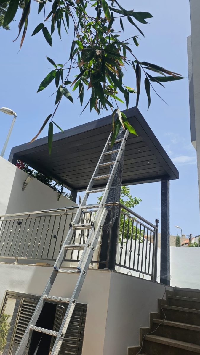 Auvent métallique et garde-corps en inox sur une terrasse, en cours de pose