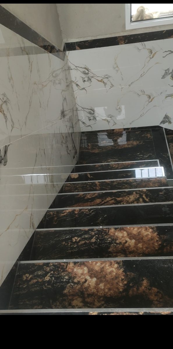 Escalier habillé de carrelage effet marbre blanc et noir doré