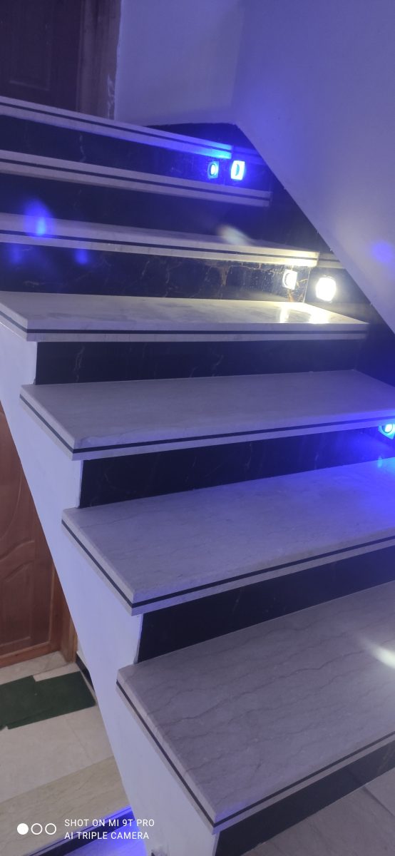 Escalier habillé de marbre gris et noir à éclairage LED bleu
