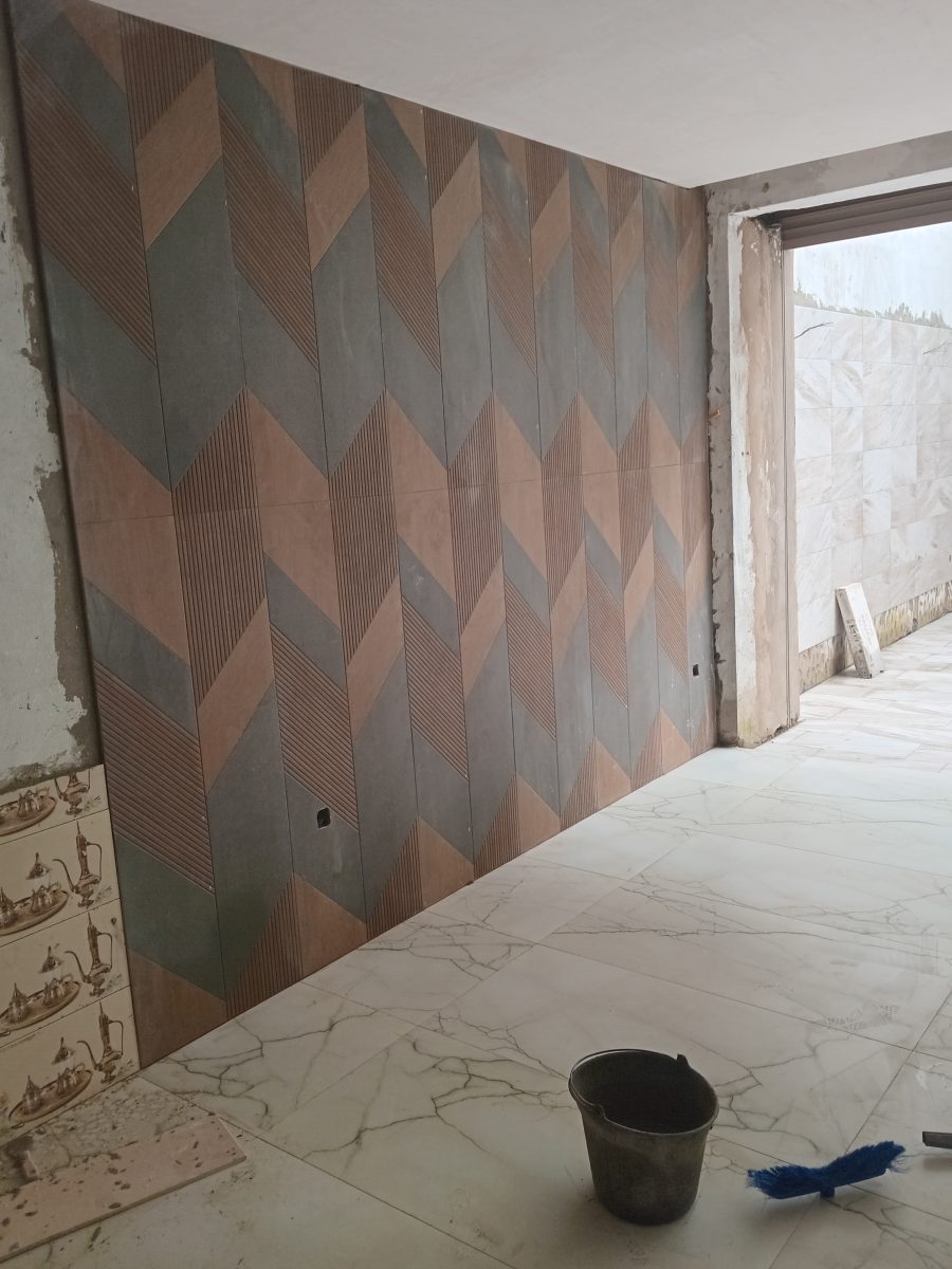 Mur habillé de carrelage à motif chevron gris et terracotta
