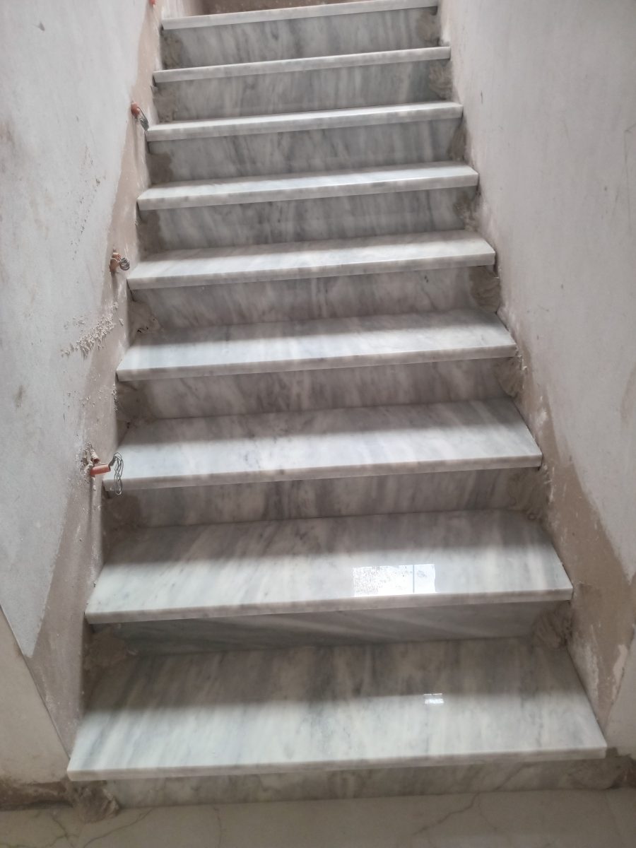 Escalier habillé de marbre gris veiné, en cours