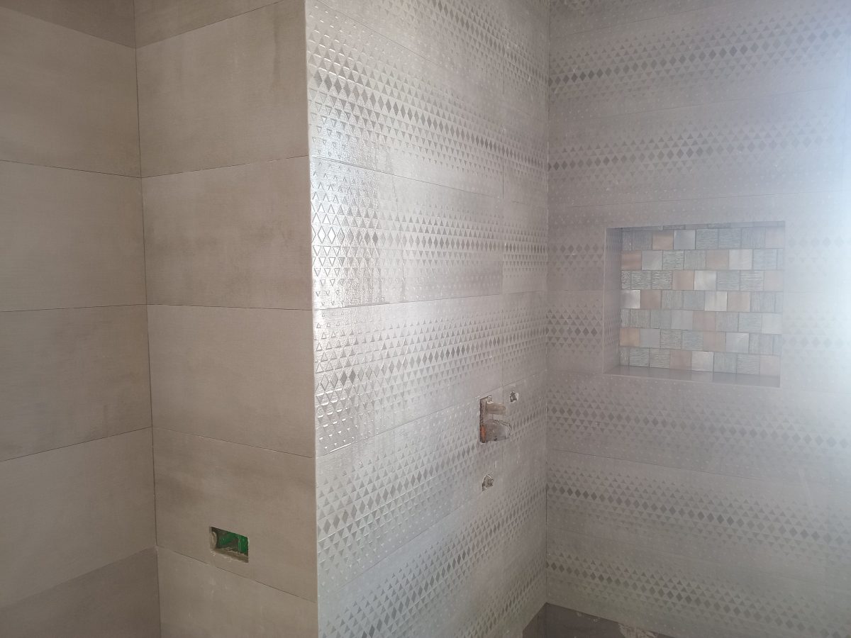 Salle de bain en faïence effet béton à frise et niche mosaïque
