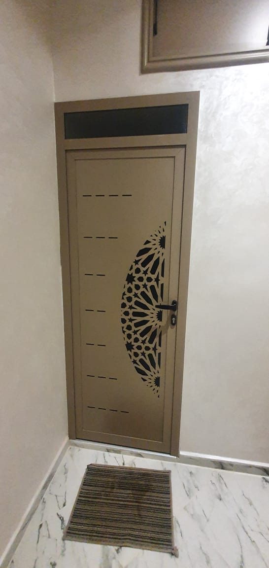 Porte en aluminium taupe à panneau découpé au laser arabesque