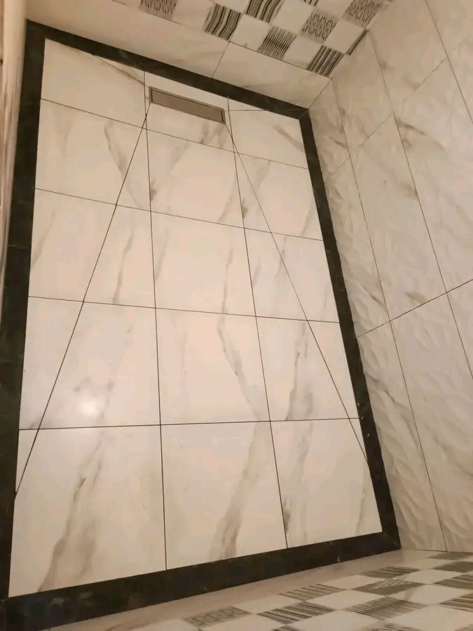 Receveur de douche carrelé effet marbre avec bordure noire et caniveau